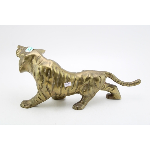 142 - A vintage brass statue of a tiger. Height 9cm, width 39th.