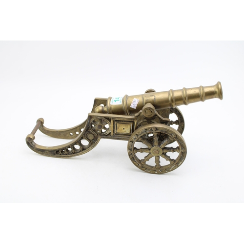 143 - A large brass model of a canon. Height 20cm, width 45cm.