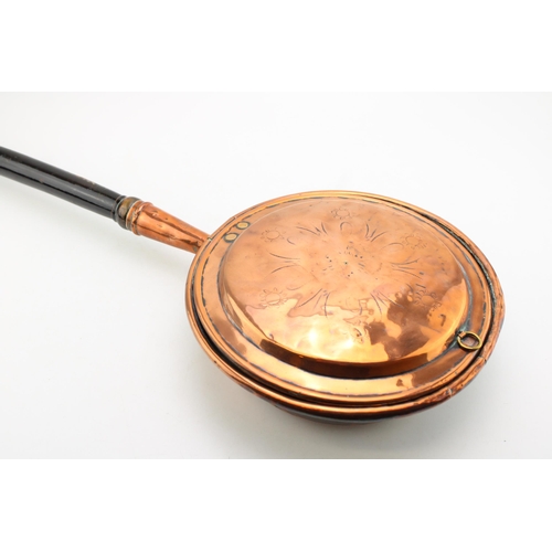 146 - An antique copper bed warming pan. 106cm.