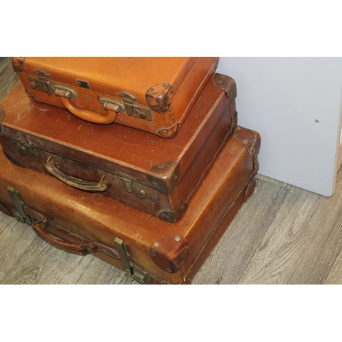 175 - A collection of three vintage trunks / suitcases in graduated sizes.