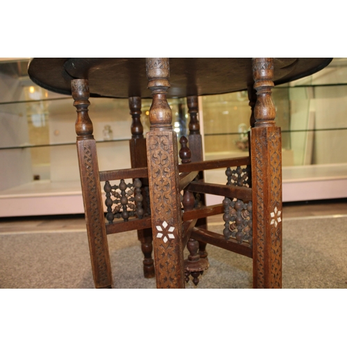 244 - A vintage middle eastern copper and brass topped occasional table with hand carved collapsible base.... 