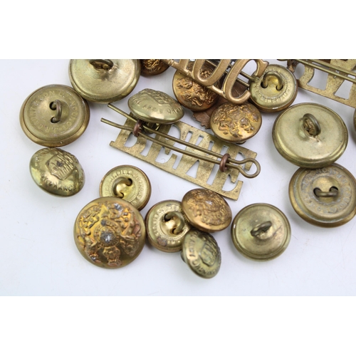 84 - A collection of military buttons to include Royal Army Ordanance Core cap badge and similar items to... 