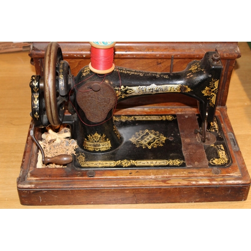 90 - A vintage 'Singer'  hand crank sewing machine complete with accessories in original case. Height 31c... 