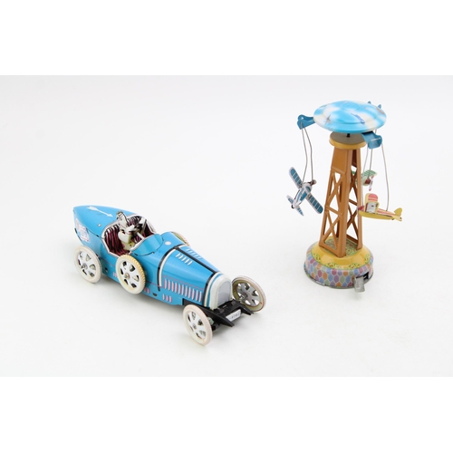 99 - Two clockwork tinplate toys to include a vintage style motorcar with driver and a tower with three a... 