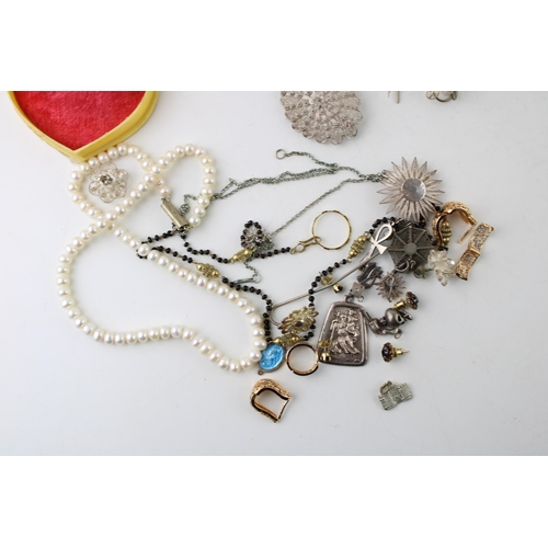 13 - A group of silver and costume jewellery including a string of button pearls, a group of silver charm... 