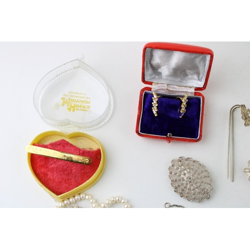 13 - A group of silver and costume jewellery including a string of button pearls, a group of silver charm... 