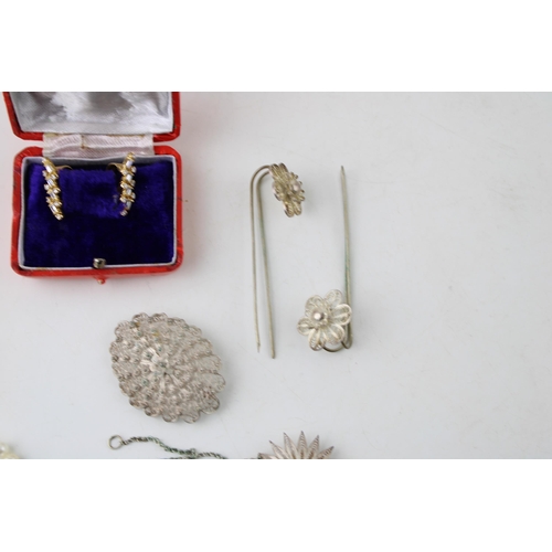 13 - A group of silver and costume jewellery including a string of button pearls, a group of silver charm... 