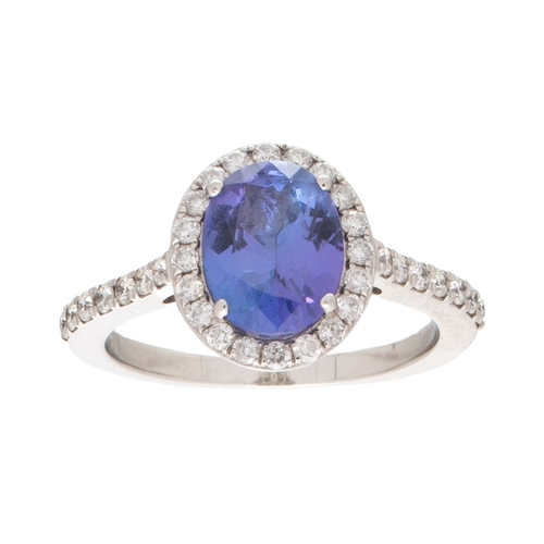 223 - A tanzanite and diamond halo platinum ring, the central tanzanite oval cut stone of approximately 9.... 