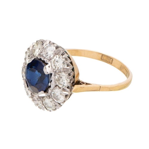 An Art Deco 18ct gold, platinum, sapphire and diamond dress ring, the central deep royal blue sapphire of approximately 8.1mm diameter, 2.5ct, surrounded by ten diamonds each approximately 4.3mm diameter, 0.25ct, totalling approximately 2.5ct, ring size Q, total weight 5.7g.  Diamonds appear well matched and reasonably bright and white, and clear with a few minor inclusions just visible under a 10x loupe.