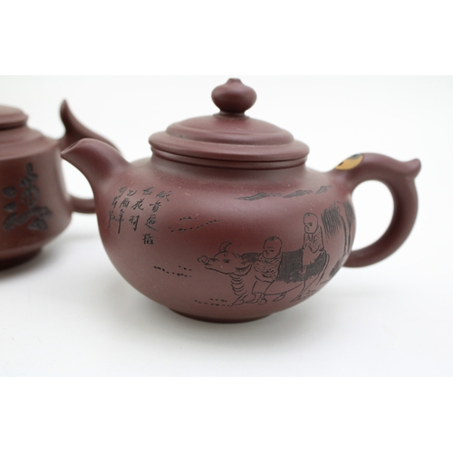 1142 - Two ceremonial Chinese clay tea pots, one with hand scribed decoration depicting rural scene with ch... 