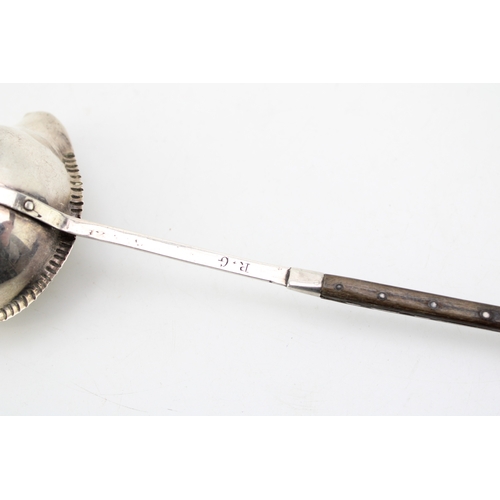 125 - A George III silver toddy ladle with baleen twist handle, the bowl with beaded rim and pouring spout... 