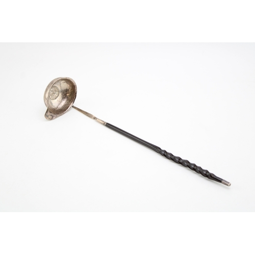 127 - A George III silver toddy ladle, the oval bowl inset with 1787 half crown, with baleen twist handle.