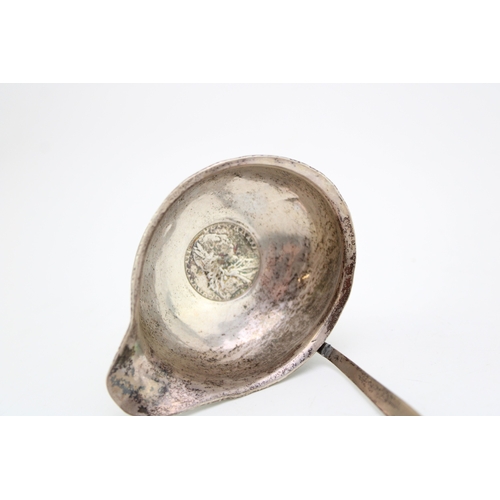 127 - A George III silver toddy ladle, the oval bowl inset with 1787 half crown, with baleen twist handle.