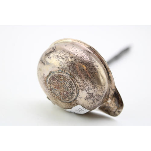 127 - A George III silver toddy ladle, the oval bowl inset with 1787 half crown, with baleen twist handle.