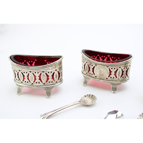 152 - A pair of silver Walker & Hall table salts with cranberry glass liners hallmarked Sheffield 1896. to... 