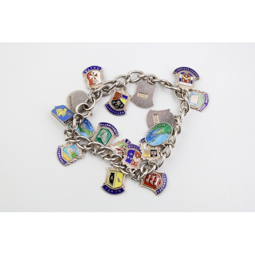 173 - A silver charm bracelet with enamel place name charms to include Guernsey, Bala Lake, Towyn and othe... 