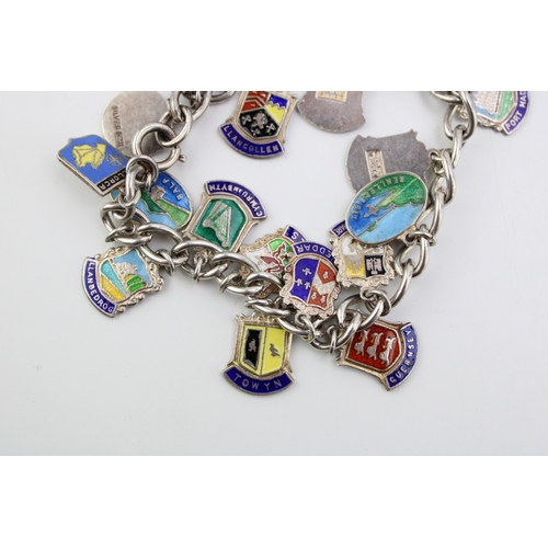 173 - A silver charm bracelet with enamel place name charms to include Guernsey, Bala Lake, Towyn and othe... 