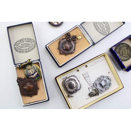 192 - A collection of fobs and medals to include Fattorini & Sons fobs in original boxes, a silver example... 