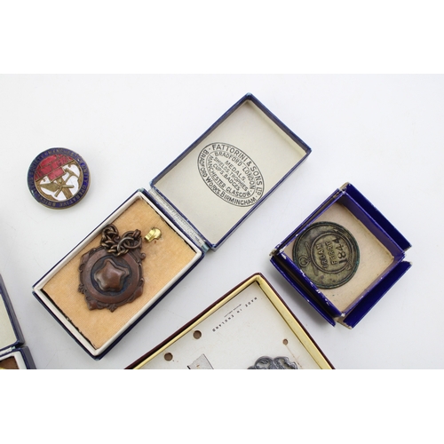 192 - A collection of fobs and medals to include Fattorini & Sons fobs in original boxes, a silver example... 