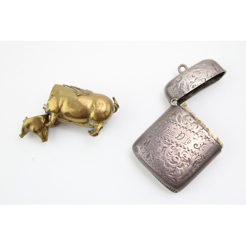 196 - A brass pig vesta case wit hinged head, sailing ship saddle and strike to the belly, together with a... 