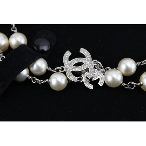 209 - A Chanel necklace of simulated pearls and diamante set interlocking Cs at intervals, in original sue... 