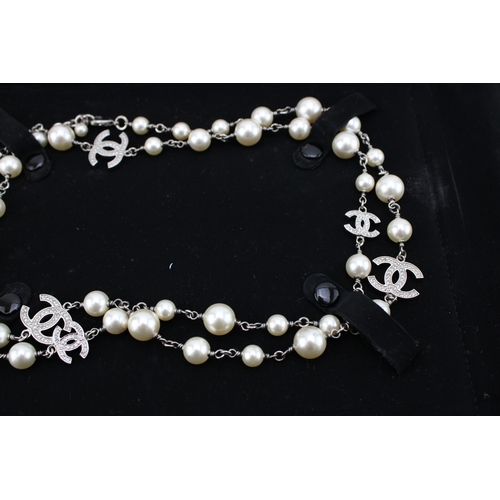 209 - A Chanel necklace of simulated pearls and diamante set interlocking Cs at intervals, in original sue... 