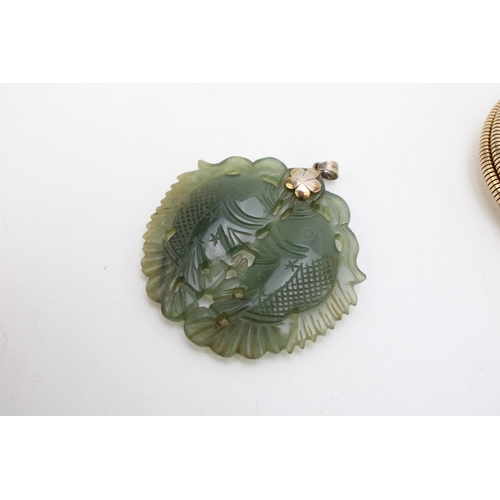 220 - A rolled gold serpent arm bangle and a spinach nephrite pendant carved as two fish, with silver flow... 