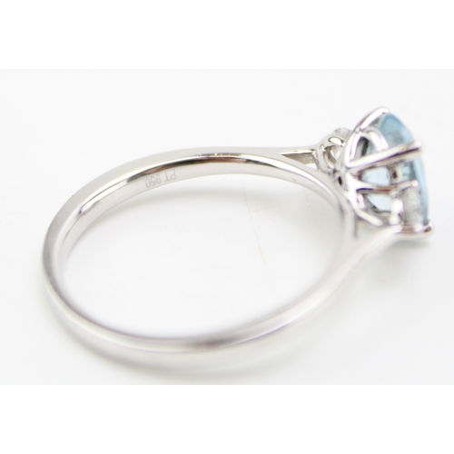 222 - A platinum, aquamarine and diamond dress ring, the oval cut stone 7.9 by 6.1mm, flanked by a diamond... 