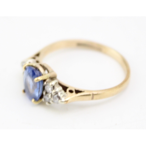 224 - A 9ct gold, sapphire and diamond dress ring, the central oval cut pale cornflower blue stone of appr... 