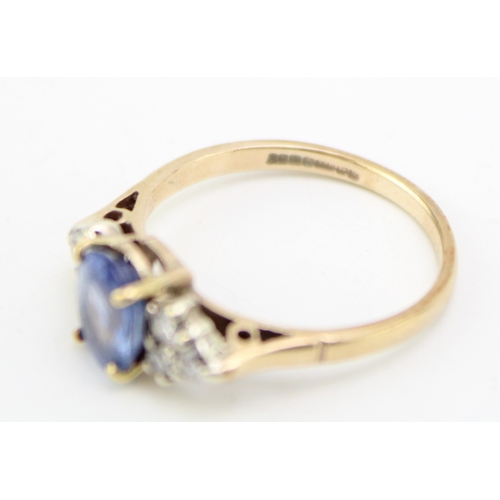 224 - A 9ct gold, sapphire and diamond dress ring, the central oval cut pale cornflower blue stone of appr... 