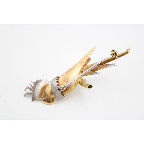 242 - A white and yellow gold brooch modelled as a cockatoo perched on a branch with sapphire eye, with te... 