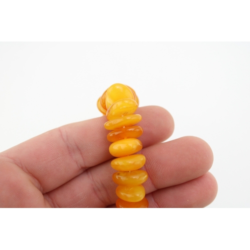 263 - Two strings of butterscotch and clear amber, comprising a string of uneven button beads, total weigh... 