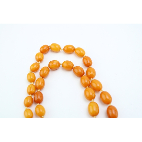 264 - A string of vintage graduated oval butterscotch amber beads, largest bead approximately 25.8mm, smal... 