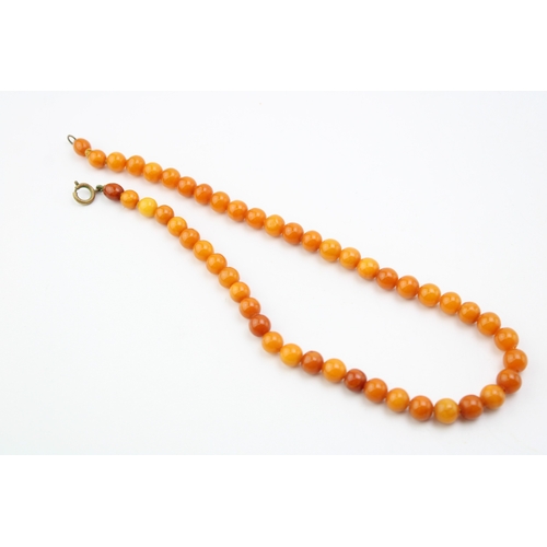 267 - A string of vintage circular beaded amber, the semi-translucent beads of slightly graduated form, 7.... 