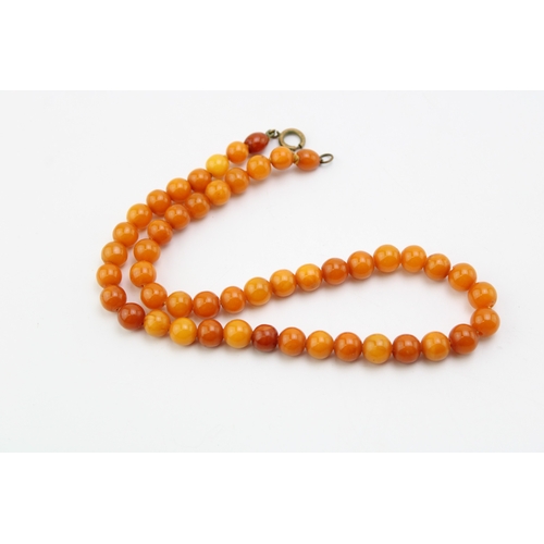 267 - A string of vintage circular beaded amber, the semi-translucent beads of slightly graduated form, 7.... 