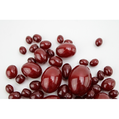 279 - A group of bakelite cherry amber beads, of graduated oval form, the largest 30.9 by 23.2mm the small... 