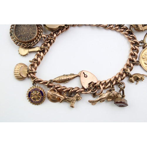 283 - A 9ct gold curb link charm bracelet with eighteen charms, including pyramid which opens to reveal mu... 