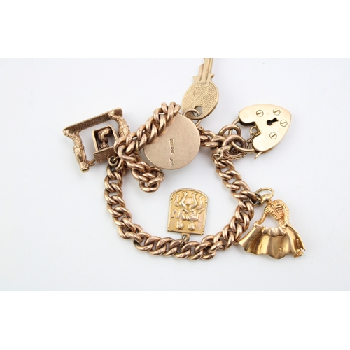 284 - A 9ct gold curb link charm bracelet with heart shaped padlock clasp and five charms, comprising a to... 