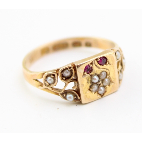 289 - A Victorian 15ct gold ring set with seed pearls and rubies, with central plaque depicting a daisy wi... 