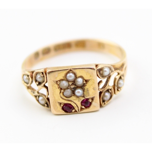 289 - A Victorian 15ct gold ring set with seed pearls and rubies, with central plaque depicting a daisy wi... 