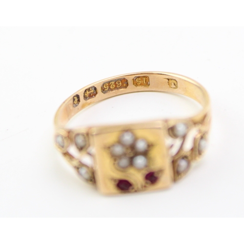 289 - A Victorian 15ct gold ring set with seed pearls and rubies, with central plaque depicting a daisy wi... 