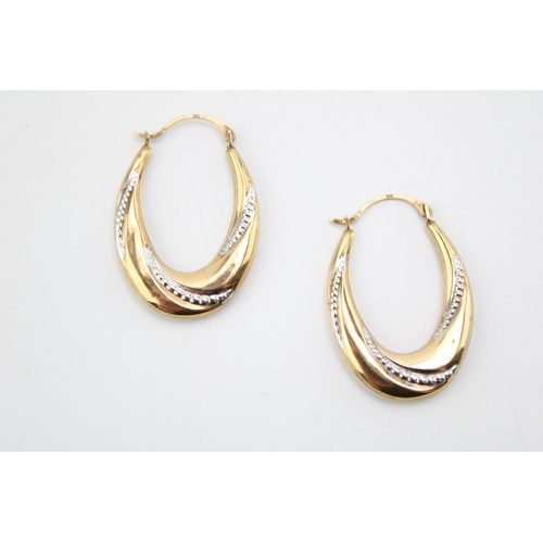 318 - A pair of 9ct yellow and white gold twist hoop earrings, 1.8g.