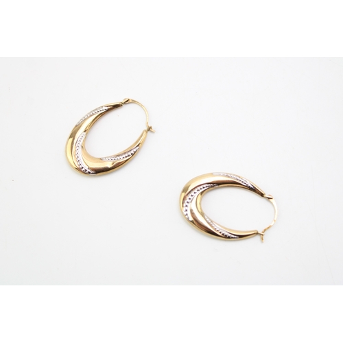 318 - A pair of 9ct yellow and white gold twist hoop earrings, 1.8g.