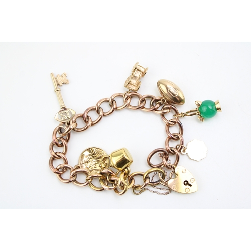 436 - A 9ct gold curb link charm bracelet with heart shaped padlock clasp and seven charms comprising kett... 