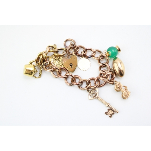 436 - A 9ct gold curb link charm bracelet with heart shaped padlock clasp and seven charms comprising kett... 