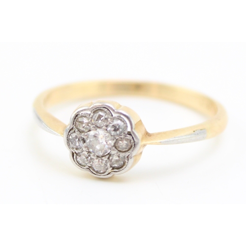 445 - An 18ct gold and diamond vintage flowerhead ring, the central diamond of approximately 3.3mm diamete... 