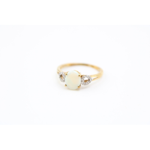 458 - A 10ct gold opal and diamond dress ring, set with oval opal of approximately 8.9 by 7.3mm, the heart... 