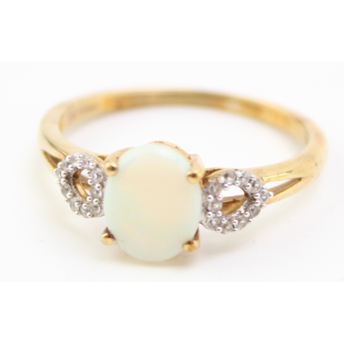 458 - A 10ct gold opal and diamond dress ring, set with oval opal of approximately 8.9 by 7.3mm, the heart... 