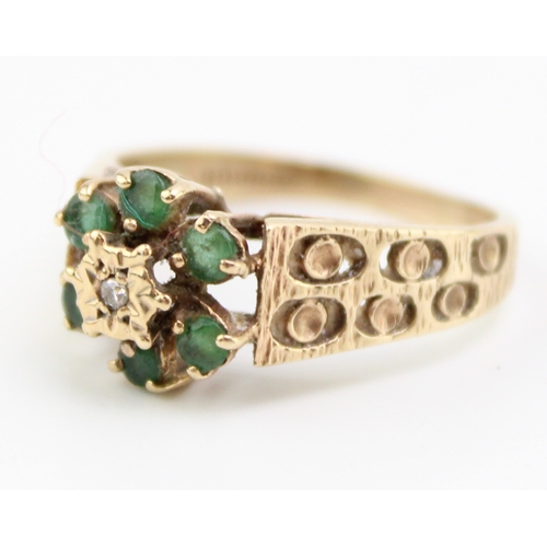 459 - A vintage 9ct gold emerald and diamond flowerhead ring in the Brutalist style, set with six emerald ... 