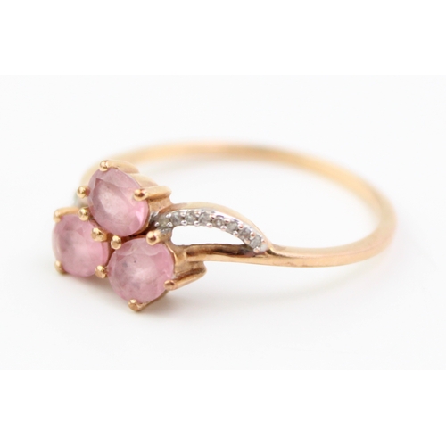 464 - A 9ct gold, pink sapphire, and diamond dress ring, set with three oval cut pale pink sapphires, with... 